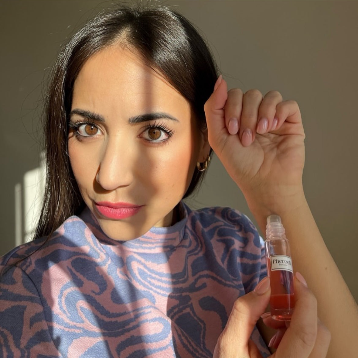 Femme appliquant le parfum Pheroeli sur son poignet
